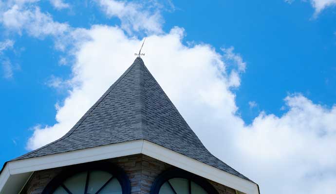 Church steeple with a shingled roof