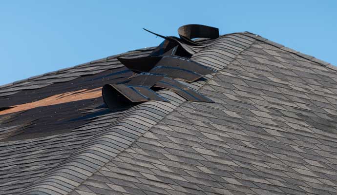 Close-up view of damaged shingles on a commercial roof