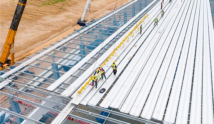 Professionals installing roof in commercial building