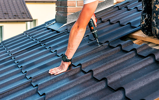 Workers installing metal roofing panels.