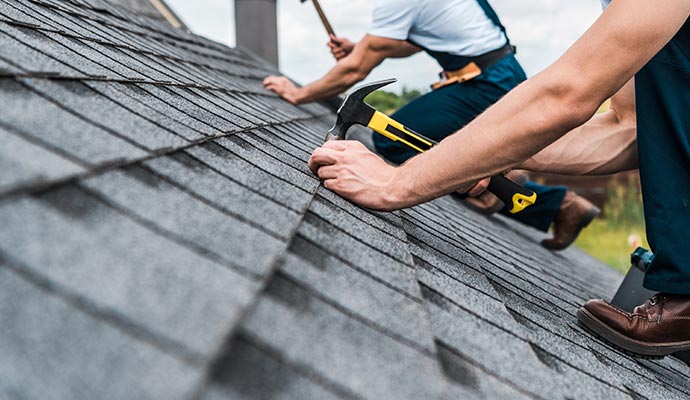 Professional repairing a roof with tools