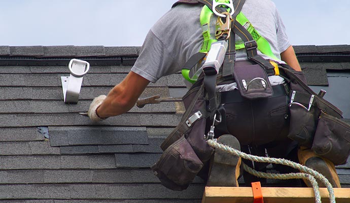 Professional repairing a damaged roof