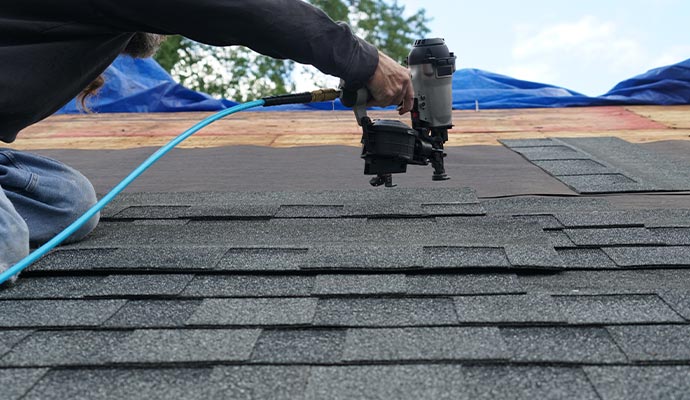 Person installing roof on the house