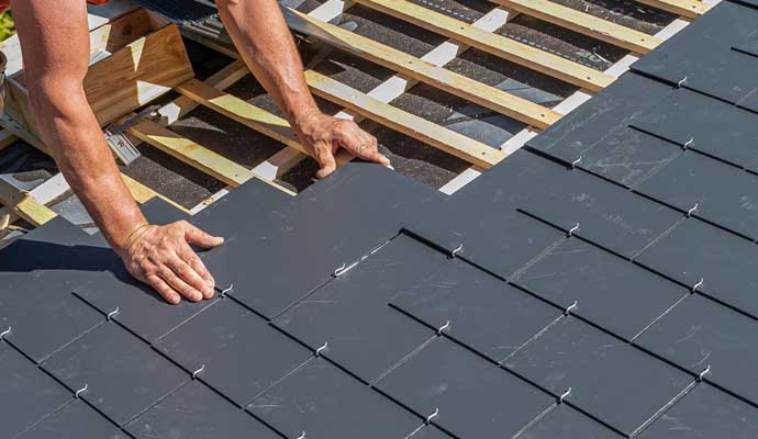 Professional installing new slate shingle roof