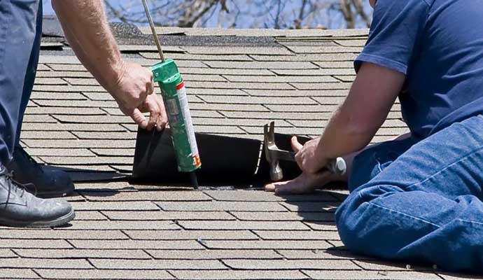 Professional team repairing missing shingles roof