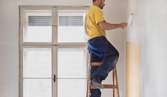 Professional painting a room wall