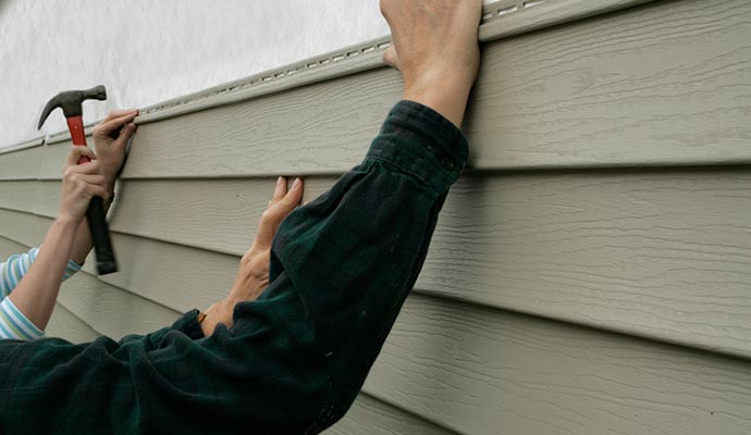 Professional team installing vinyl siding