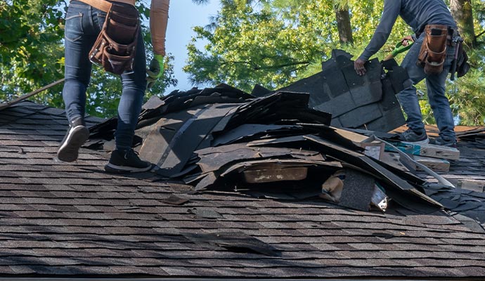 Professional team restoring a storm-damaged house roof