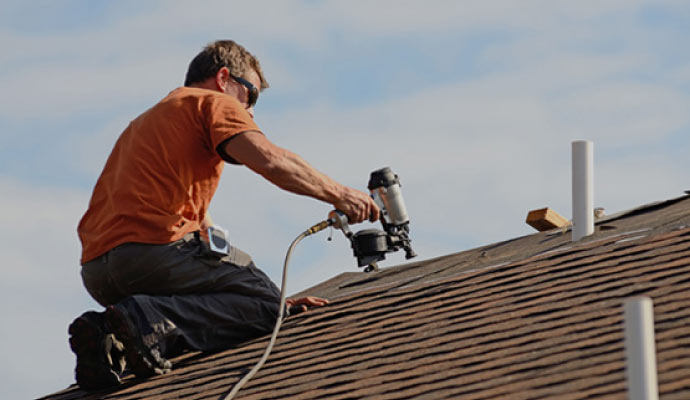 Person repairing the roof after storm with equipment